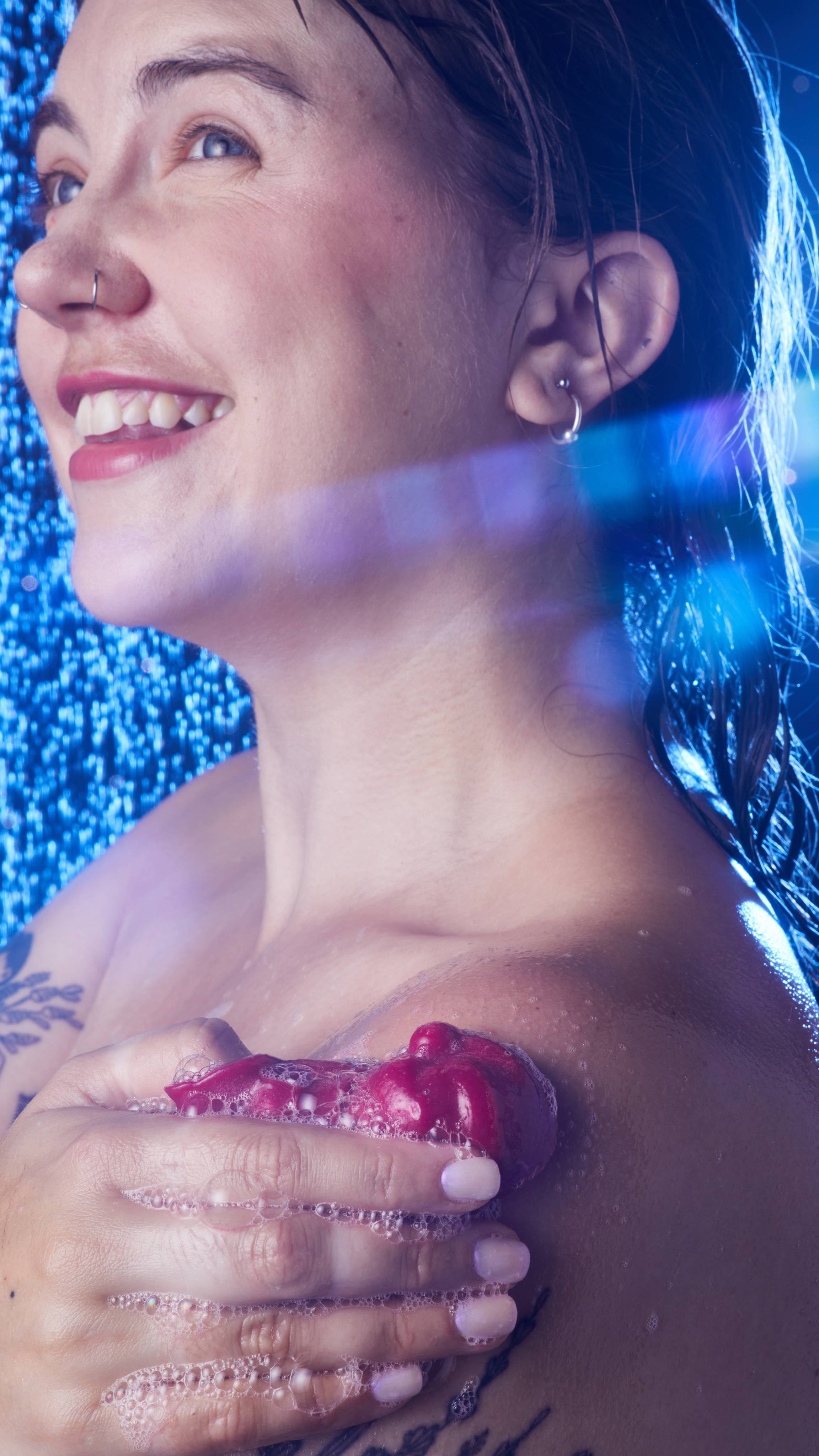 Image shows the model in the shower as they lather up their shoulder with the Bouncing Santa shower jelly. 