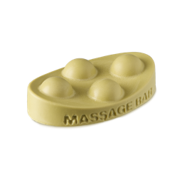 Brazilian Boom. An ivory-yellow, solid oil massage bar in an oval shape. The words "massage bar" are embossed on the side and there are four raised half-sphere, bubble-type shapes on top. 