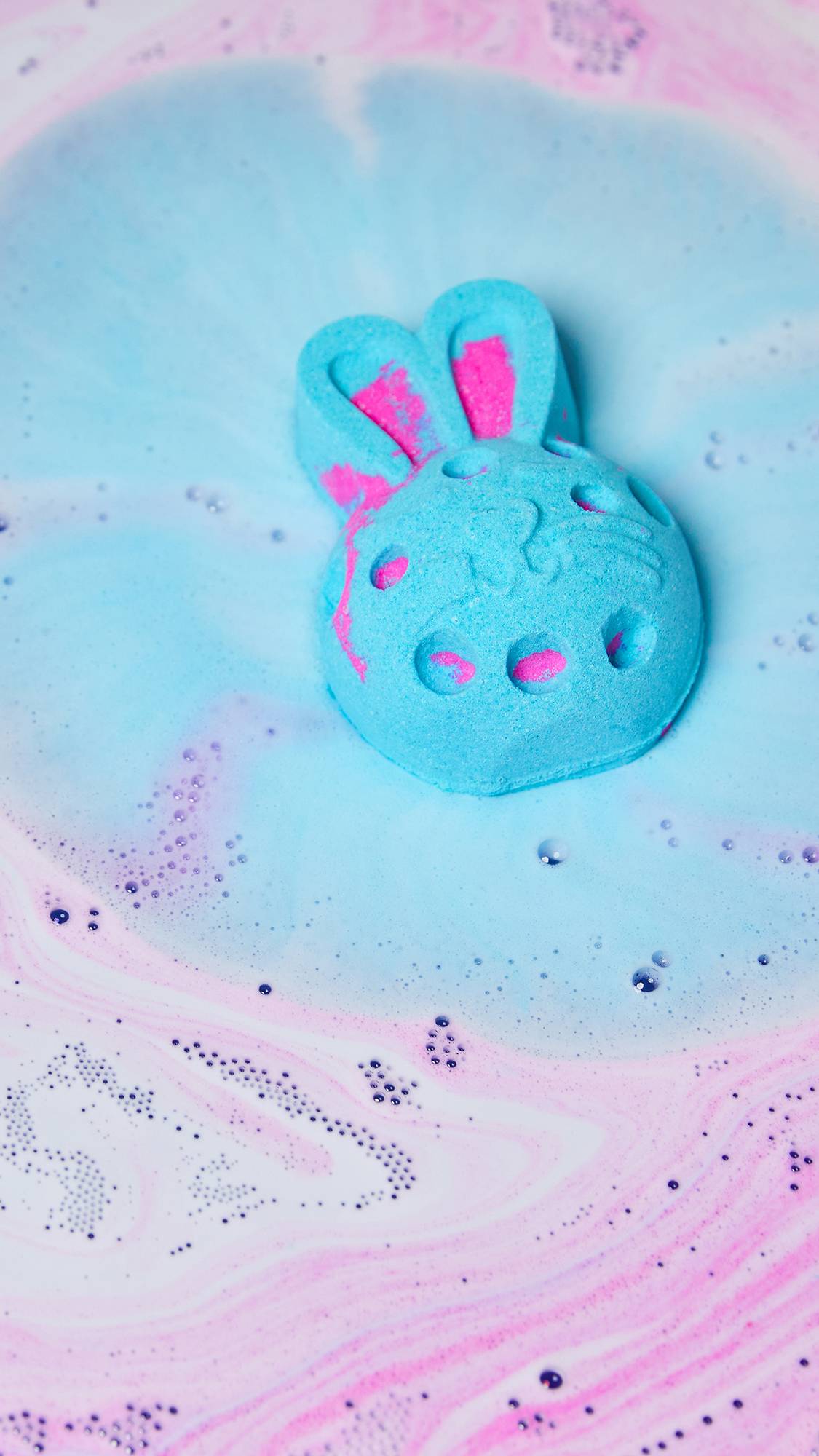 The Bunny Moon bath bomb dissolved in the water giving off thick bubbly swirls of velvety pink and blue foam.