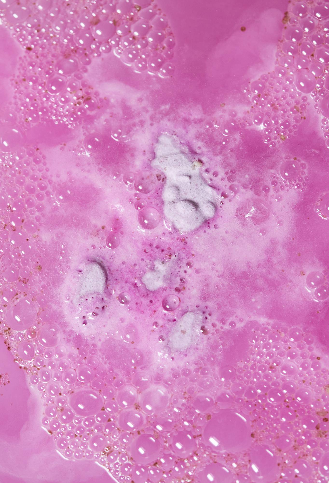 Butterbear bath bomb has nearly fully dissolved leaving deep fuchsia pink water. 