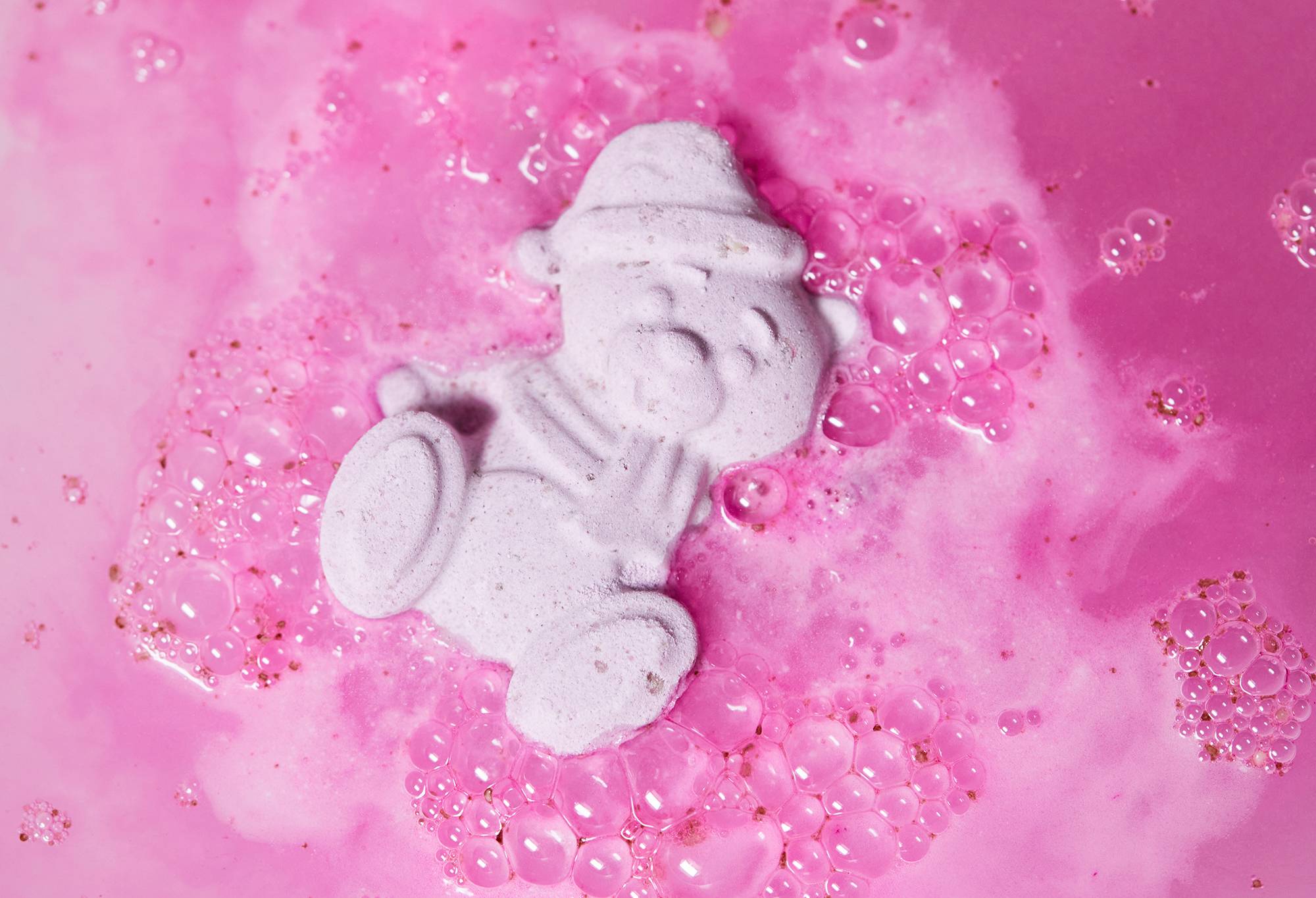 Butterbear floats among vibrant, hot-pink foamy waters. 