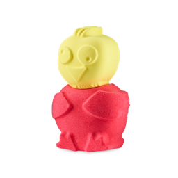 A yellow and pink Chirpy Chick bath bomb stands against a plain grey background. The top half is a yellow chick head with carved eyes and a beak, while the bottom half is a round pink body with wing and feet details.