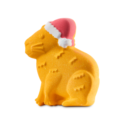 Christmas Capybara. A fun, colourful bath bomb shaped like a golden-brown, sitting Capybara wearing a classic red and white Santa hat. 