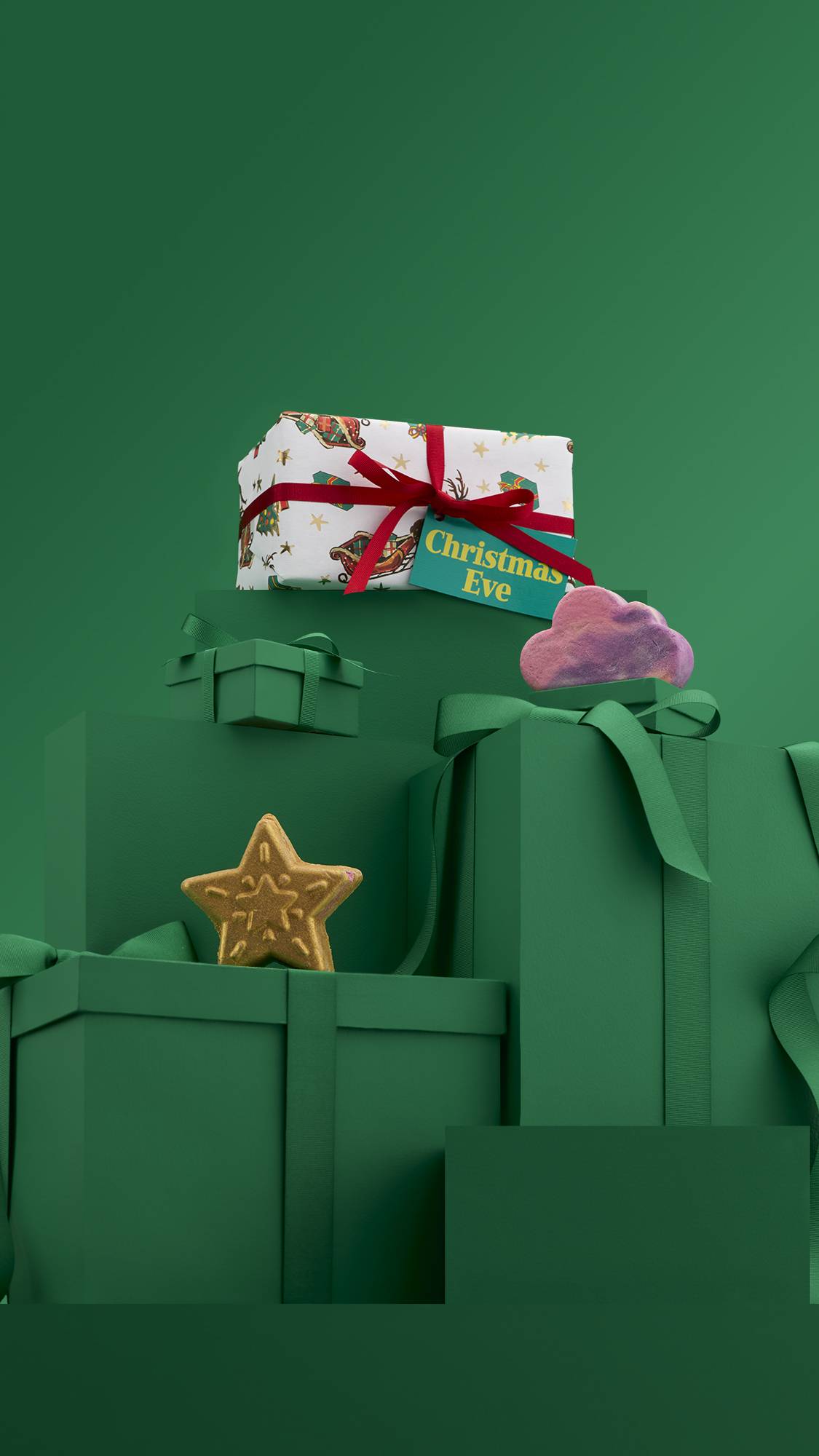 The image shows a large pile of differently-sized wrapped green gifts with ribbons, on a matching green background. The colourful Christmas Eve gift box sits on top of the pile, and the two included products sit on lower green gifts. 