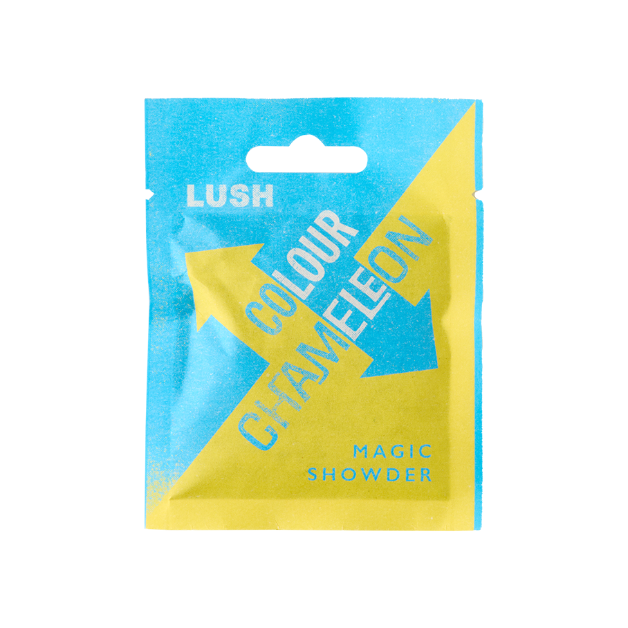 Colour Chameleon. The image shows a colourful, sealed, paper sachet with a bold blue and yellow arrow pattern on. The name reads "LUSH Colour Chameleon. Magic Showder" in white text on the front.