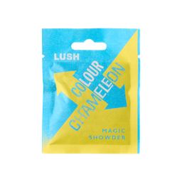 Colour Chameleon. The image shows a colourful, sealed, paper sachet with a bold blue and yellow arrow pattern on. The name reads "LUSH Colour Chameleon. Magic Showder" in white text on the front.