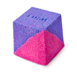 A cube-shaped Deep sleep Salt Cube bath bomb split diagonally into vibrant purple and neon pink. The purple top surface features the embossed "LUSH" logo.