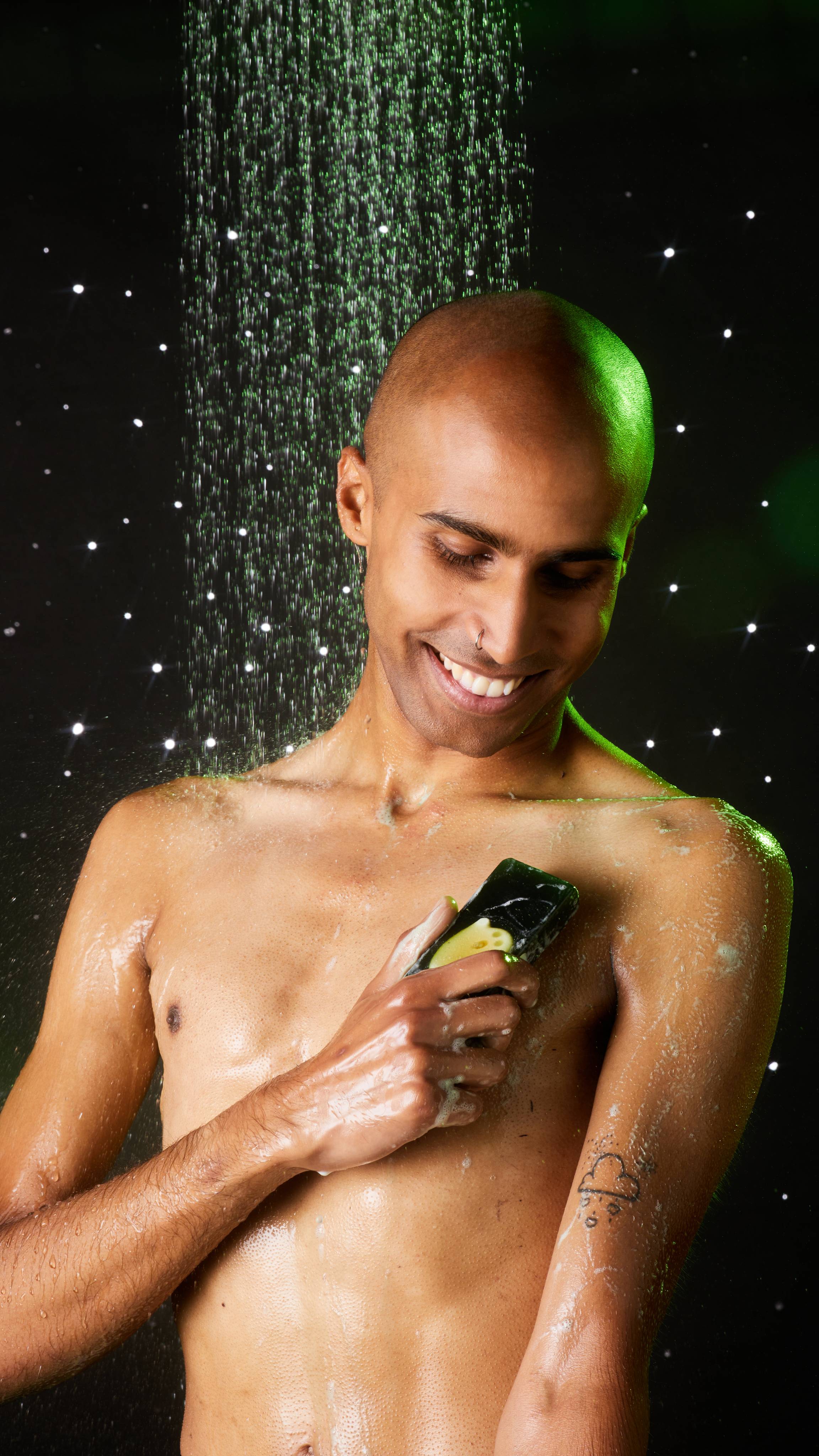 Model stands under running shower on a twinkly background as the lather up the Demon in the Dark soap over their torso.