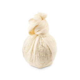 Dream Cream Soak. A round bath bomb product wrapped in a light cream muslin cloth pouch, tied with a knot at the top. Small petals and leaves are just visible through the fabric.