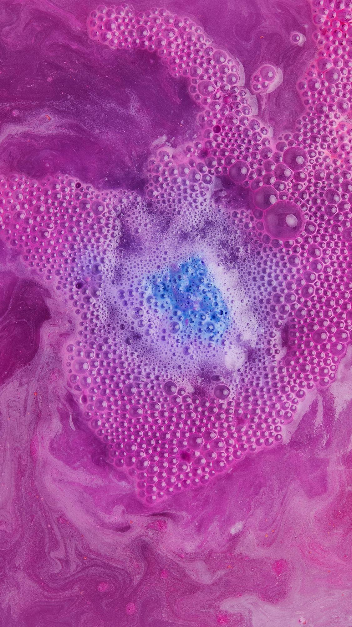 Dreidel, Dreidel, Dreidel bath bomb almost fully dissolved leaving a pastel purple among a sea of enchanting pink bubbles.