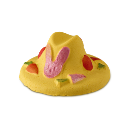Easter Bonnet. A colourful, fun bubble bar in the shape of a traditional, woven bonnet. It is bright yellow and has a decorative pink bunny shape in the middle with red dots on either side and carrots around the edges. 