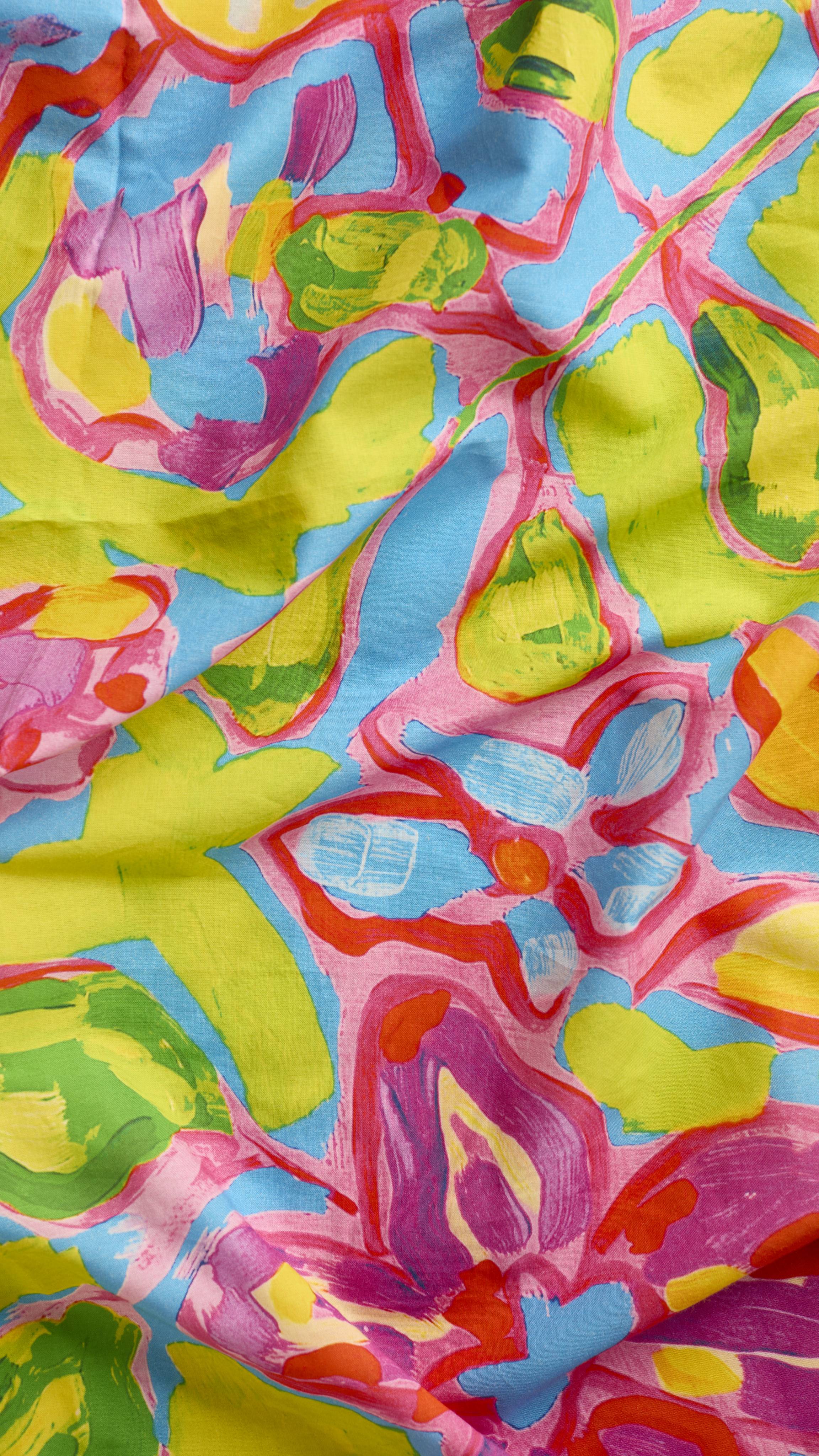 A super close-up texture shot of the "Flourish In Colour" fabric knot wrap. The image focuses on the soft texture of the knot wrap material and the vibrancy of the colours in the floral, hand-painted design.