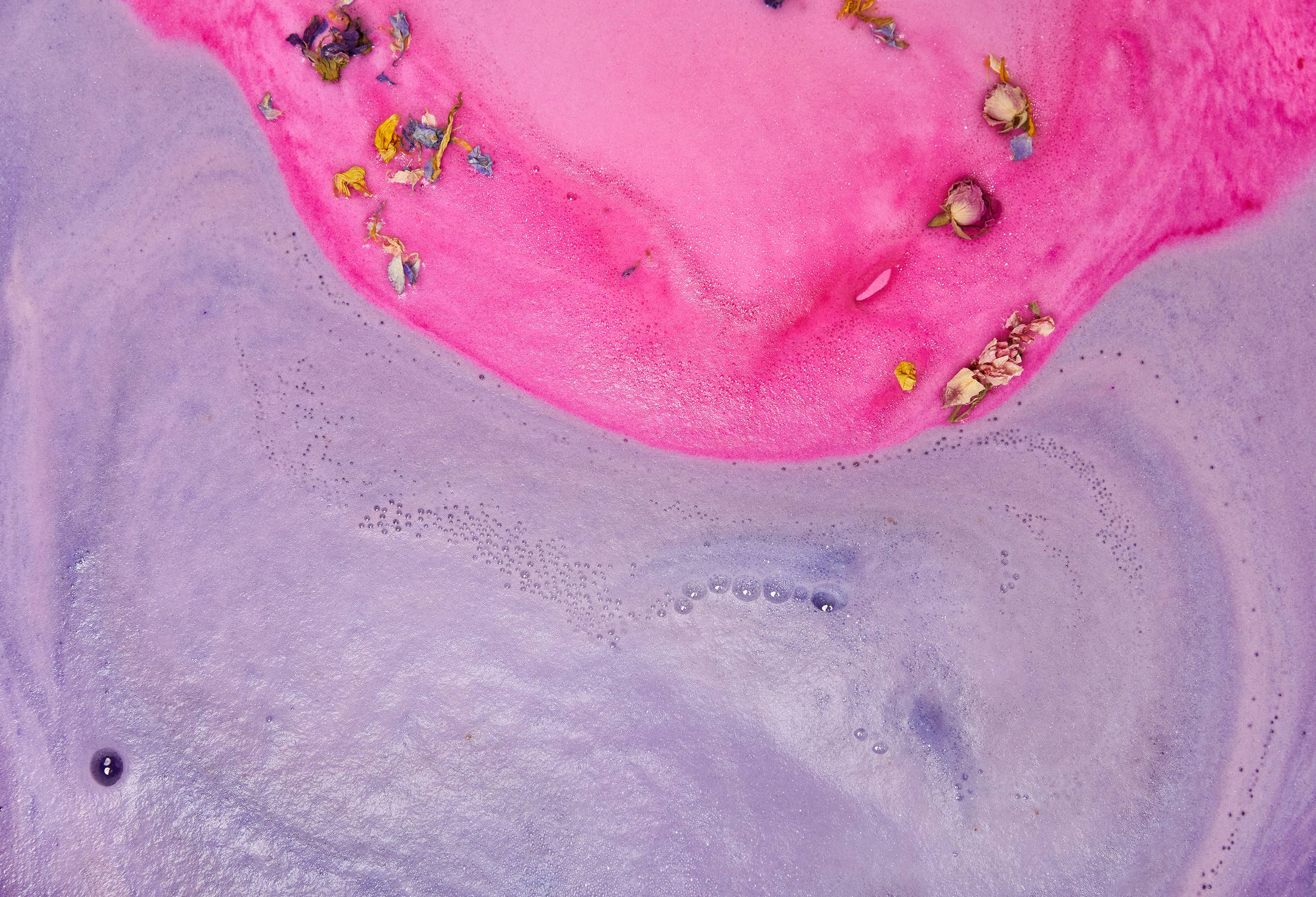 The Flower Bombshell has dissolved leaving two distinct sections of purple and pink foam, scattered with petals and flowers.