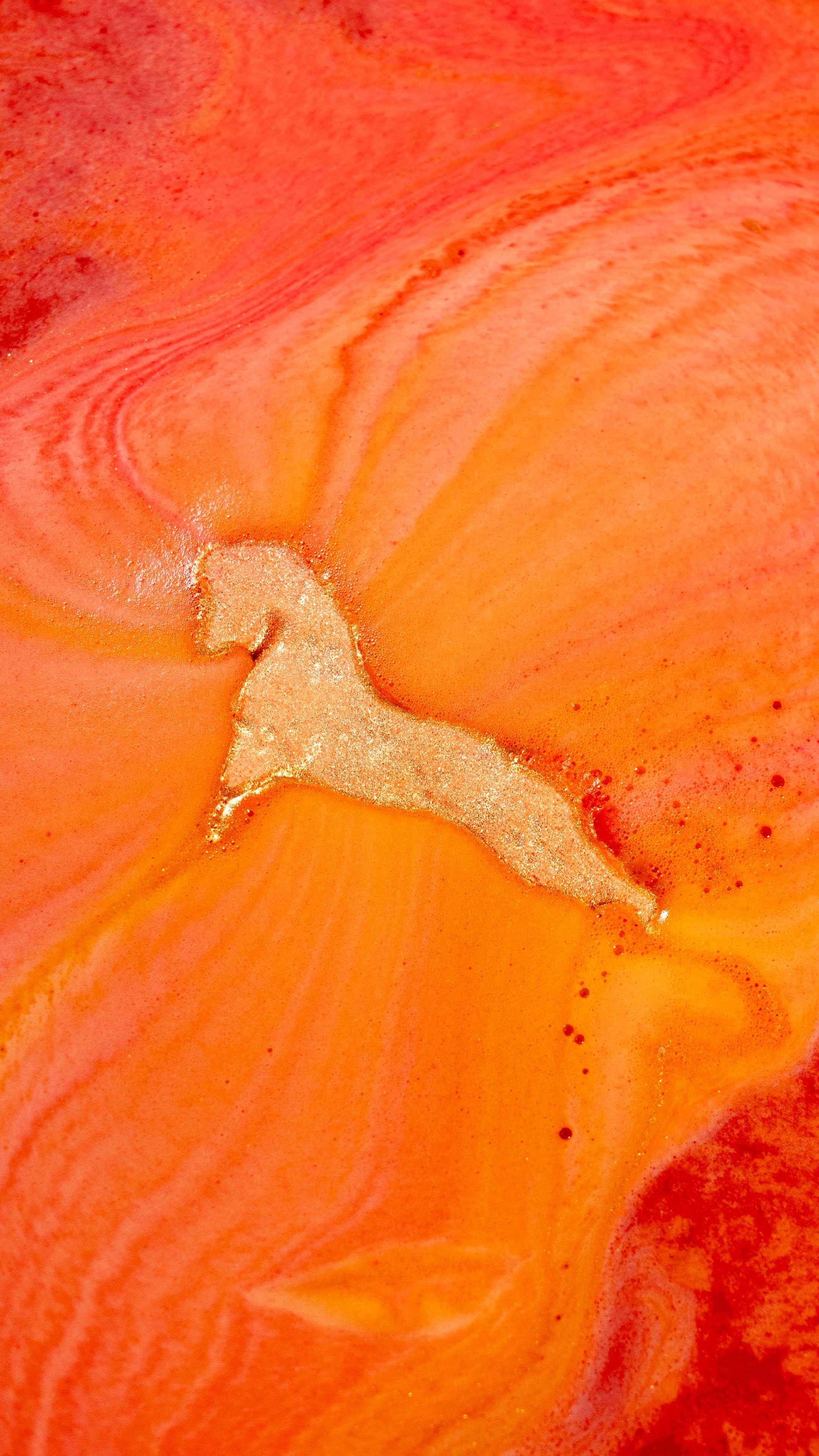 The golden horse shape of the Gallop To Success Bath Bomb dissolves into swirling orange bath art, releasing a stream of shimmering gold Plastic Free Glitter.