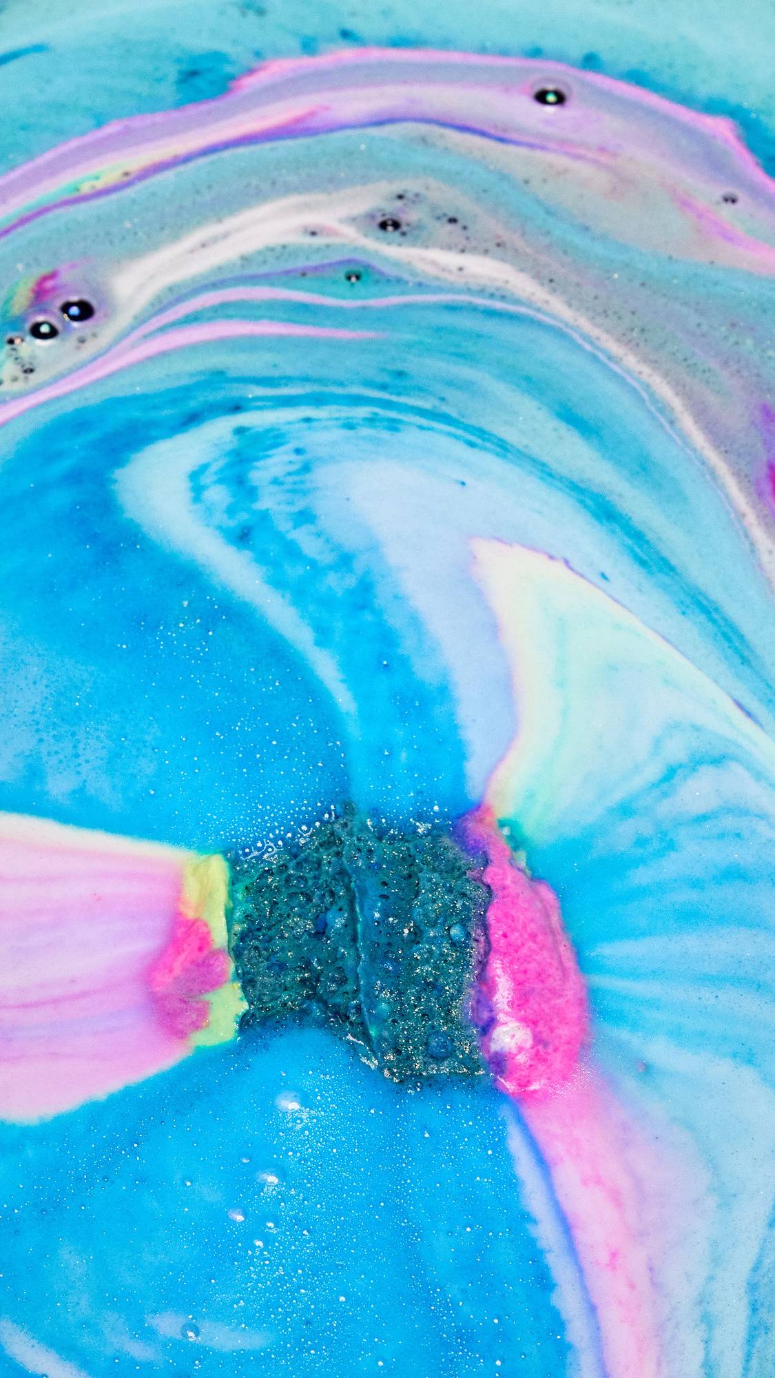 The Giant Intergalactic has been placed in the bath water and is creating a colourful galaxy of blues, purples and pinks.