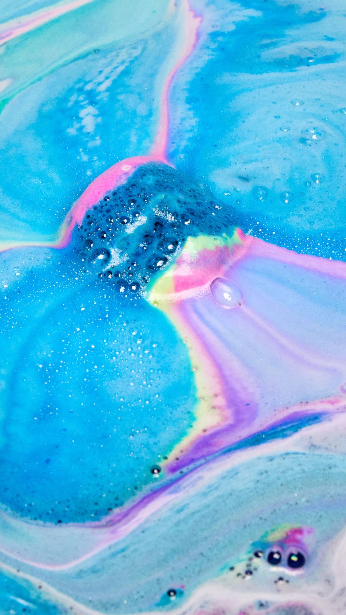 The Giant Intergalactic has been placed in the bath water and is creating a colourful galaxy of blues, purples and pinks.