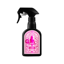 Glinda Upland. A classic, black, recycled plastic body spray bottle. There is a bright pink label on the side with a Wicked X Lush Logo and product name. 
