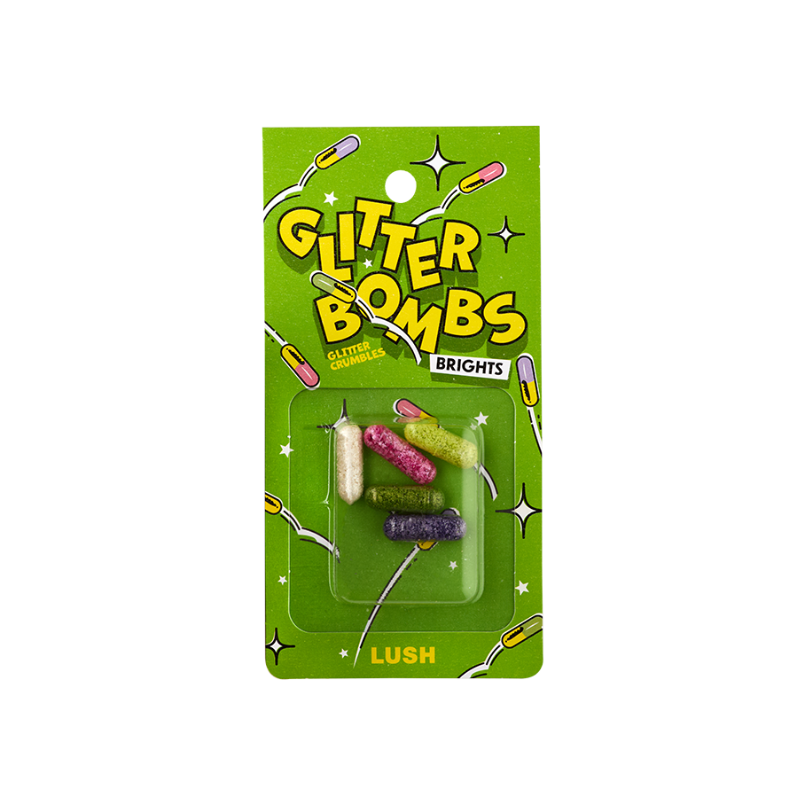 Glitter Bombs Brights. Five, small, cylindrical, pill-shaped, transparent casings filled with different coloured glitters. The packaging is bright green with illustrated pills bouncing. The Text reads: "Glitter Bombs Brights Glitter Crumble".