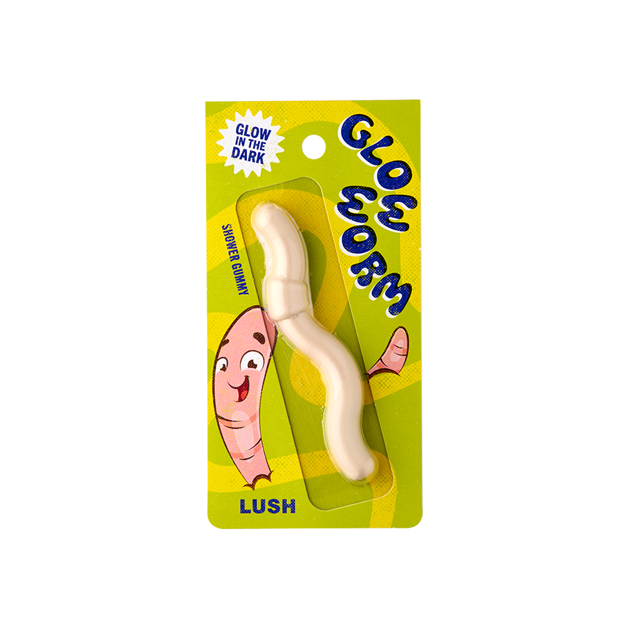Glow Worm. An off-white coloured worm-shaped shower jelly. The packaging is patterned with yellow and green swirls and a worm character illustration. The text reads "Glow in the dark Glow Worm shower gummy" 