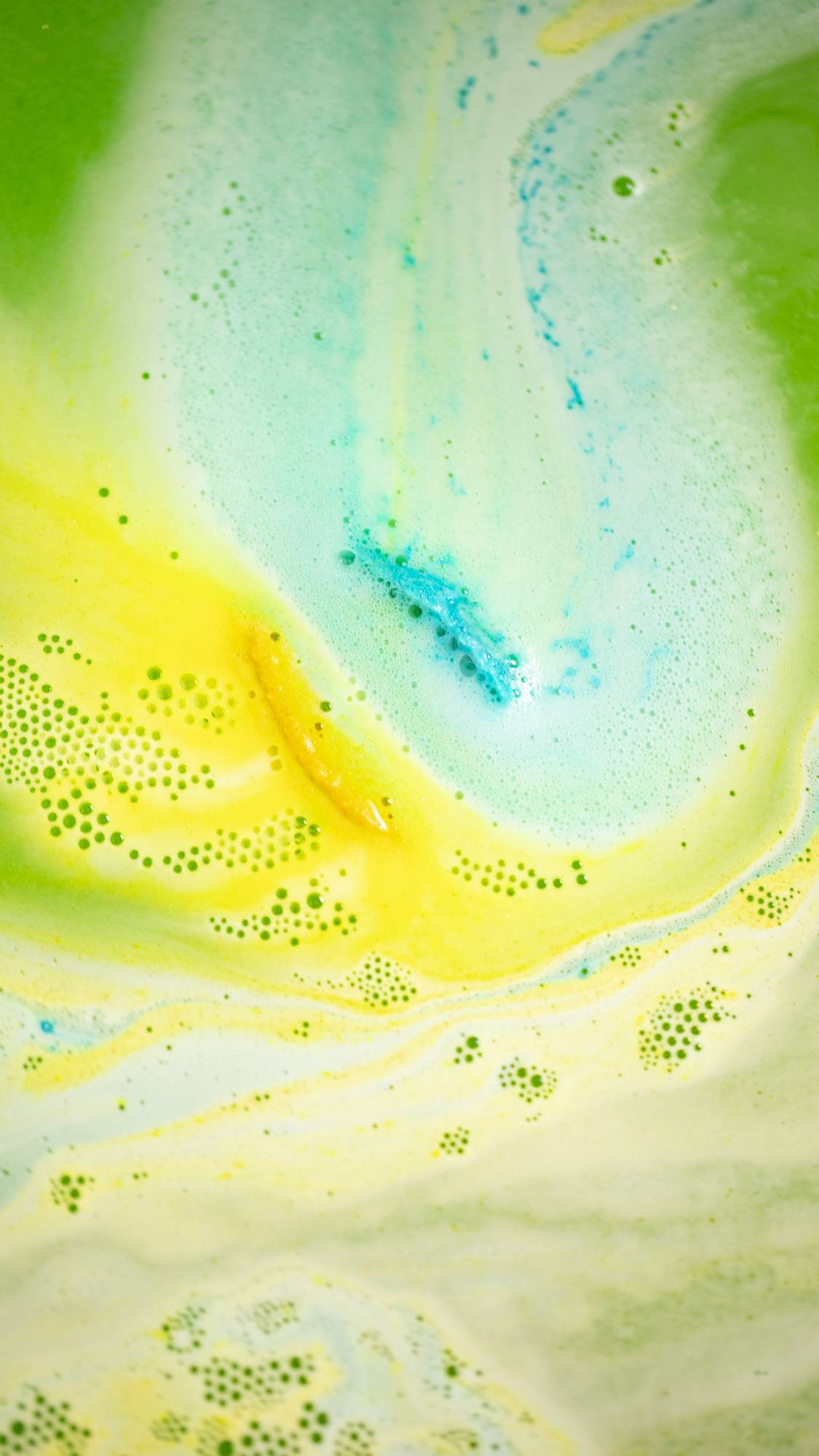 The Golden Egg bath bomb has fully dissolved leaving a thick ocean of yellow, green and blue vivid swirls. 
