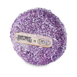 Goongala. A classic LUSH solid, circular shampoo bar. It is a deep purple colour with flecks of white. There is a rice paper label on the front showing the Teenage Mutant Ninja Turtles logo beside the Lush logo. 