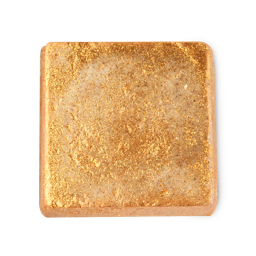 Gilded Walnut. A cube-shaped product, coated in dense, sparkling golden glitter. Its base colour appears a subtle beige, with the glitter creating a rough, textured surface.