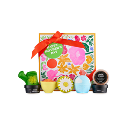 Happy Mother's Day. A square gift box designed with a floral design and red ribbon. In front is an array of products, including two bath bombs, a bubble bar, a soap, and three potted products.