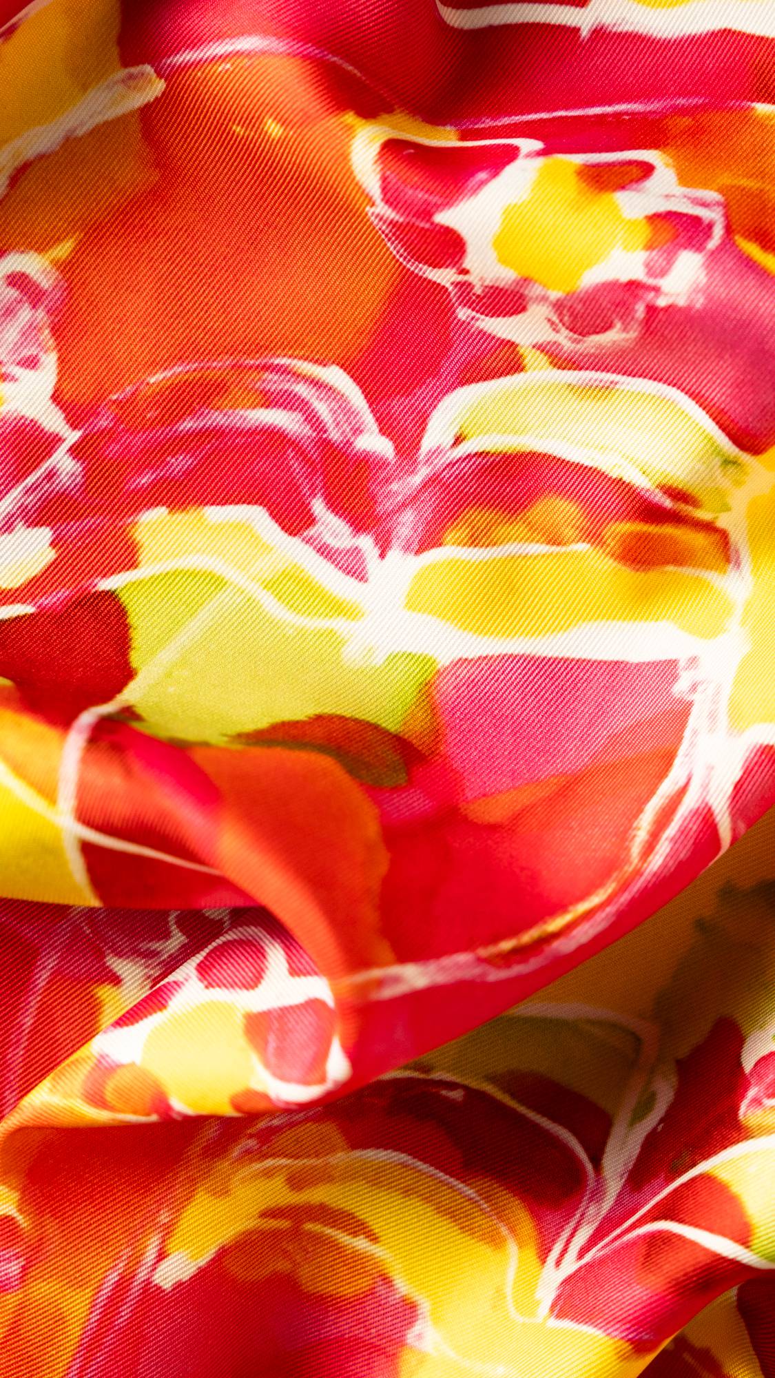 Image shows a super close up of the Hearts and Swirls knot wrap with blends of orange, red and pink with a wispy white heart.