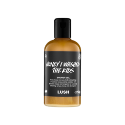 A clear bottle filled with golden creamy coloured Lush Honey I Washed The Kids
shower gel, topped with a black cap and featuring a black label