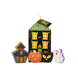 A Lush 'House of Horrors' gift. A house-shaped box stands behind four Halloween-themed bath products: a purple haunted house, an orange pumpkin, a black cat head, and a white ghost with blue and pink edges.