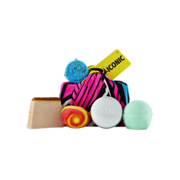 A knot-wrapped "ICONIC" gift in pink and black stripes sits surrounded by Lush products, including a soap slice, bubble bar, blue shampoo bar, tin, and mint green bath bomb.