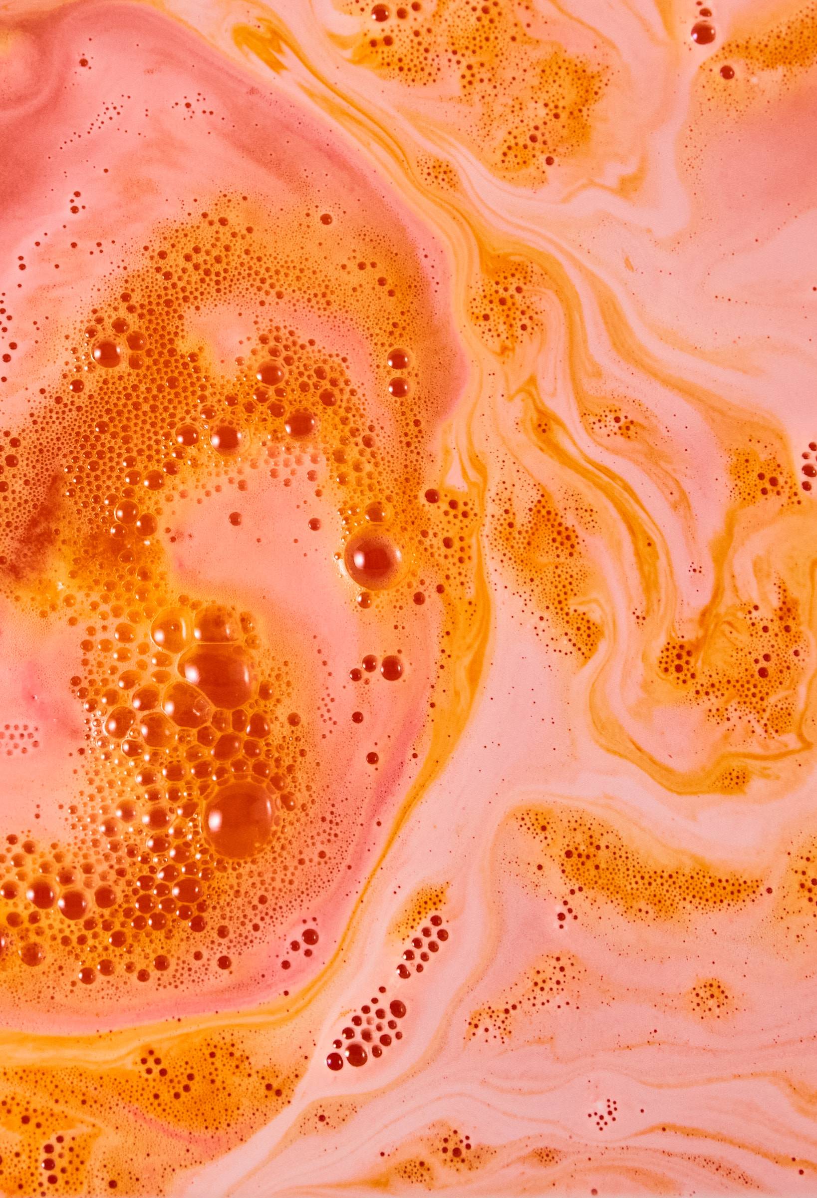 The Inner Dragon bath bomb has dissolved leaving a fiery blanket of orange and red swirls and bubbles. 