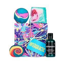 Intergalactic. A square gift box wrapped in chaotic, colourful purple, pink and blue paper, tied with a pale string. There are four Lush, Intergalactic-themed products surrounding the box. 