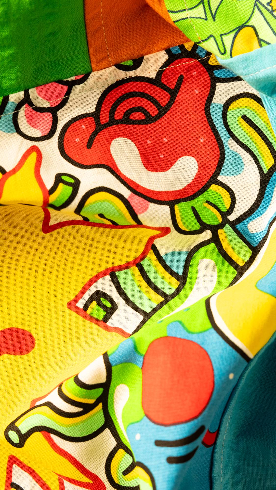 Image shows a super close-up of the Jobakbo knot wrap focusing on a large, red, illustrated rose with pops of colour.
