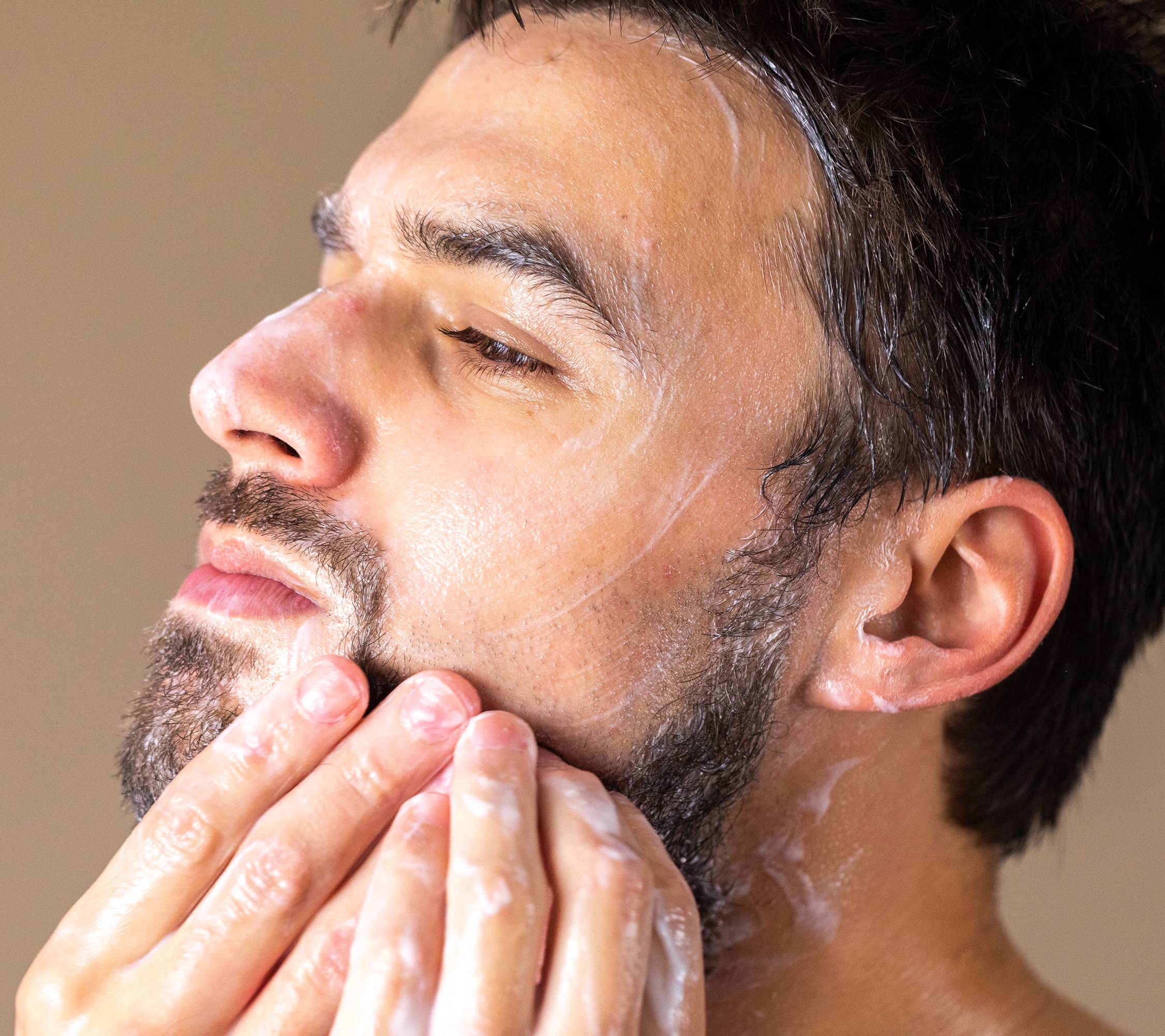 Kalamazoo, a thick, creamy coloured beard and facial wash, covers the hands, and is being worked through a dark beard.