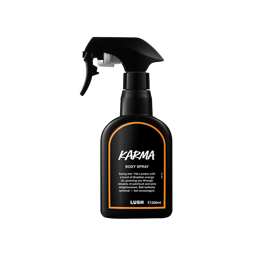 Karma body spray. A black spray bottle of Lush "Karma" Body Spray. The product label is black with a deeo orange banded border. White text states the product name and the scent description.