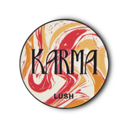Karma pin badge. A circular metal pin features a swirled pattern of red, orange, and white marbled design. The word 'KARMA' is prominent in black letters, with 'LUSH' below it.