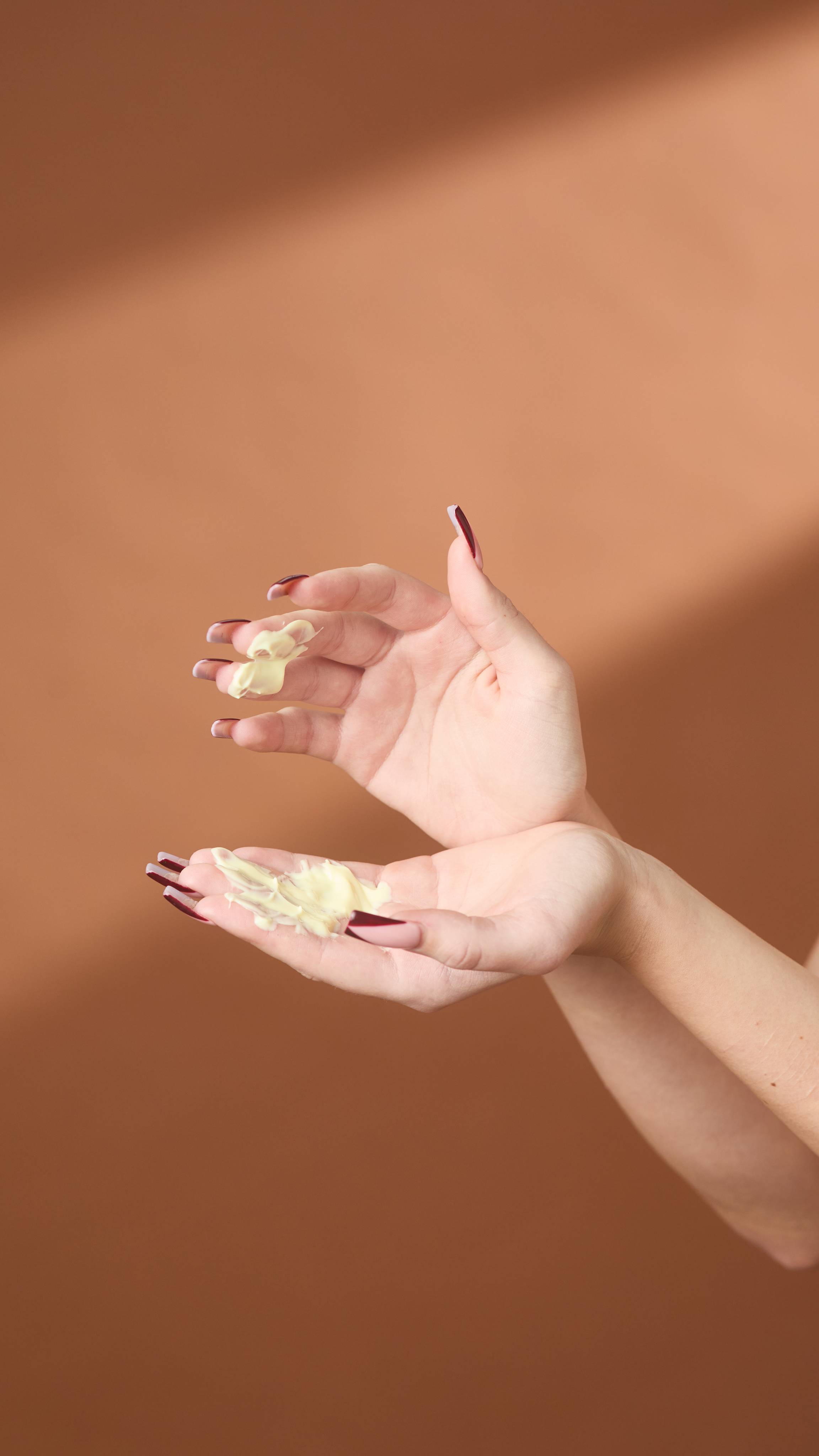 A close-up of the model's hands and forearms as they gently rub the Let The Good Times Roll body lotion between their fingers. 