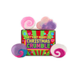 Let’s Get Ready To Christmas Crumble. An off-square-shaped gift box with a striped green and red design with star and bubble illustrations and brightly coloured text. Four Lush solid bubble bars sit on and around the box. 