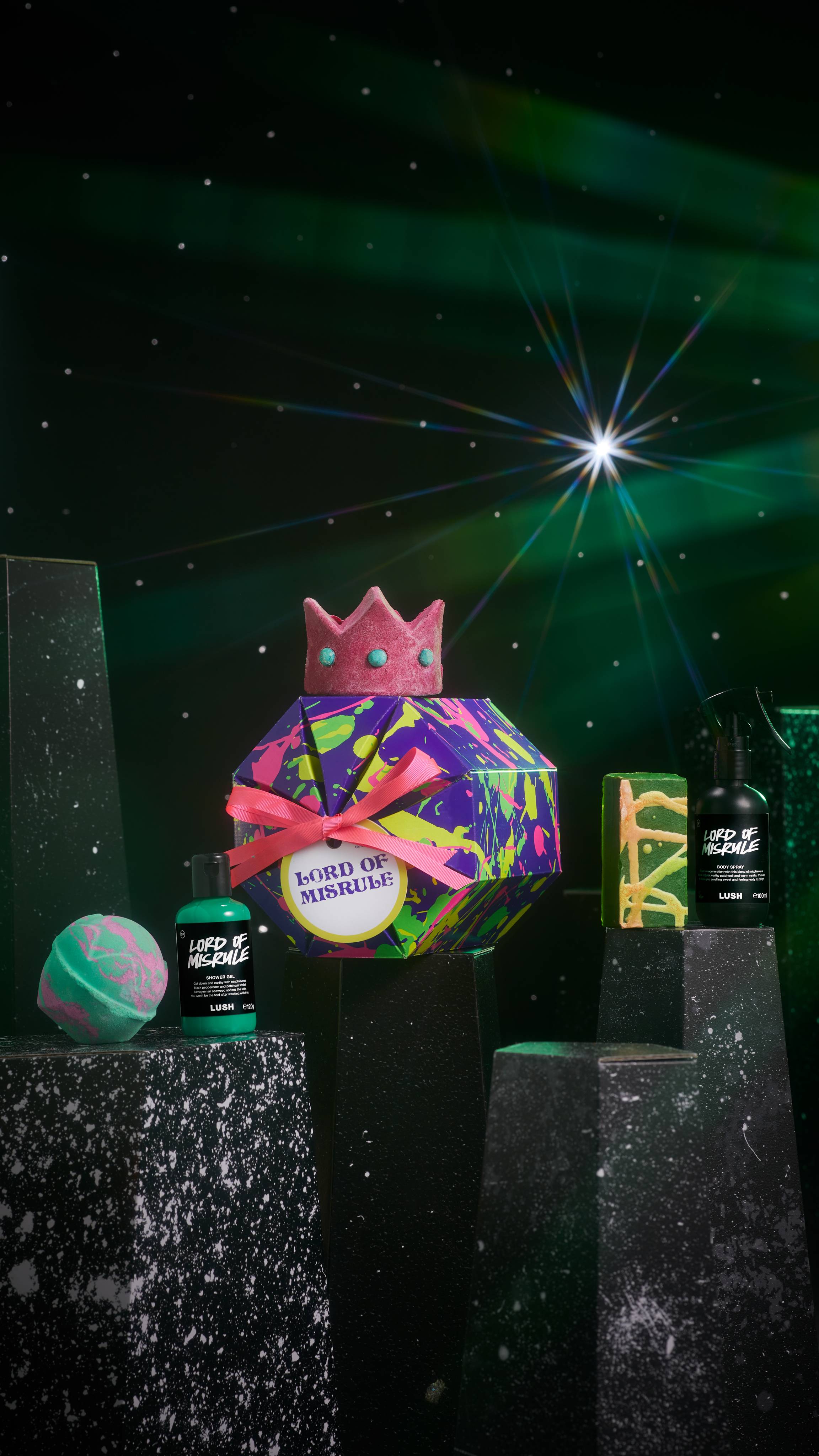 Lord of Misrule gift. A purple and splatter-designed, octagonal box surrounded by five enchanting Lord of Misrule products.