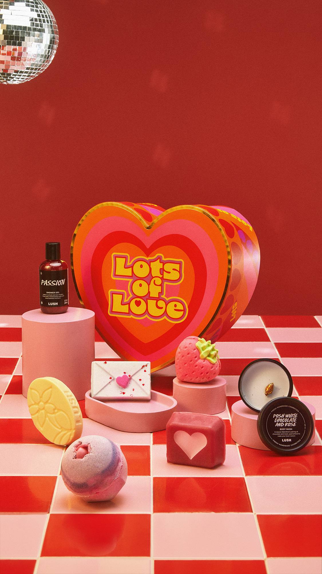 A red background with a tiled floor and a disco ball on the left. The Lots of Love gift box is surrounded by 7 products on the floor.