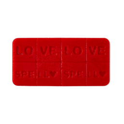 Love Spell, A rounded, rectangular wax melt. It is a deep red colour and features lines to break the product into 8. The words "Love Spell" are embossed twice, followed by a small embossed heart. 
