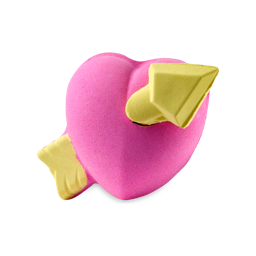 Love Struck. A colourful bath bomb shaped like a plump, pink heart with a yellow arrow piercing through it. The arrowhead is a removable stopper.