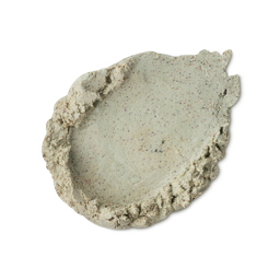 Magic Potion. A smeared swatch of thick, pale sage-green body scrub with visible fine brown speckles and textured edges