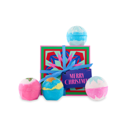 Merry Christmas. A square gift box with a colourful, block-designed snowflake, tied with a blue ribbon and purple gift tag. Four Christmas-themed bath bombs sit on and around the gift box.