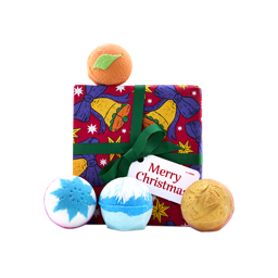 A Lush Merry Christmas gift box wrapped in red bell-patterned paper with a green ribbon, surrounded by four festive bath bombs, including a blue snowflake and an orange Clementine design