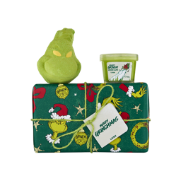 A Lush 'Merry Grinchmas' gift box wrapped in green festive Grinch paper tied with string, topped with a character face bath bomb and a tub of 'Grumpy Grinch' shower slime.
