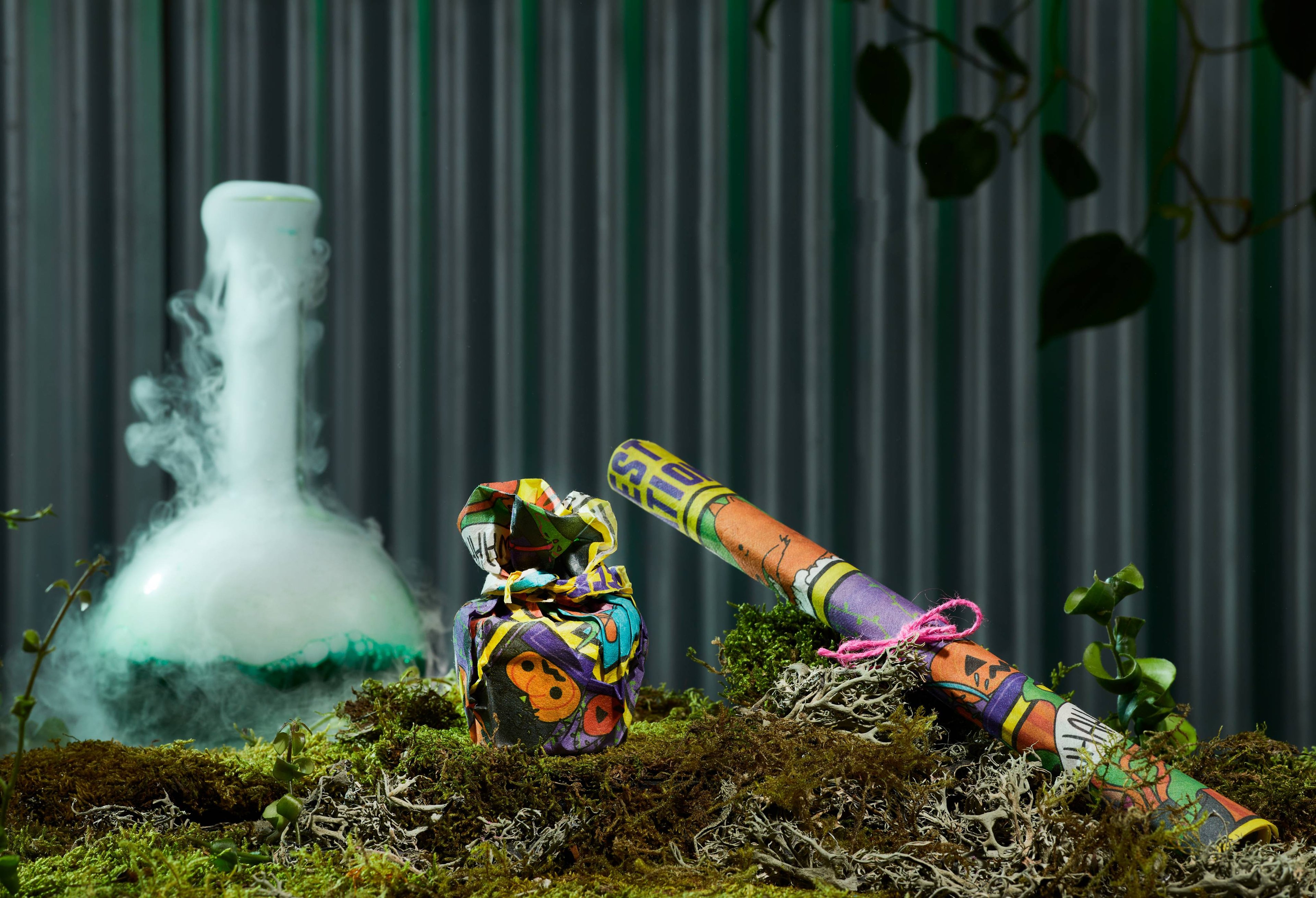 Monster House Lokta Wrap, displayed in two separate ways in front of a dark green background, on a bed of moss. 