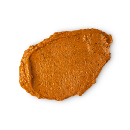 Mr. Pumpkin face mask. A neatly smudged swatch of vibrant orange face mask. It has a rough, grainy texture with visible darker flecks and prominent ridges.