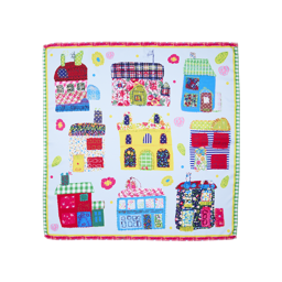 My Family Houses. A vibrant, square fabric knot-wrap features a playful, hand-drawn design of nine quirky houses. Each house uses various patterns like florals, stripes, and patchwork on a pale blue background with a pink and green checked border.